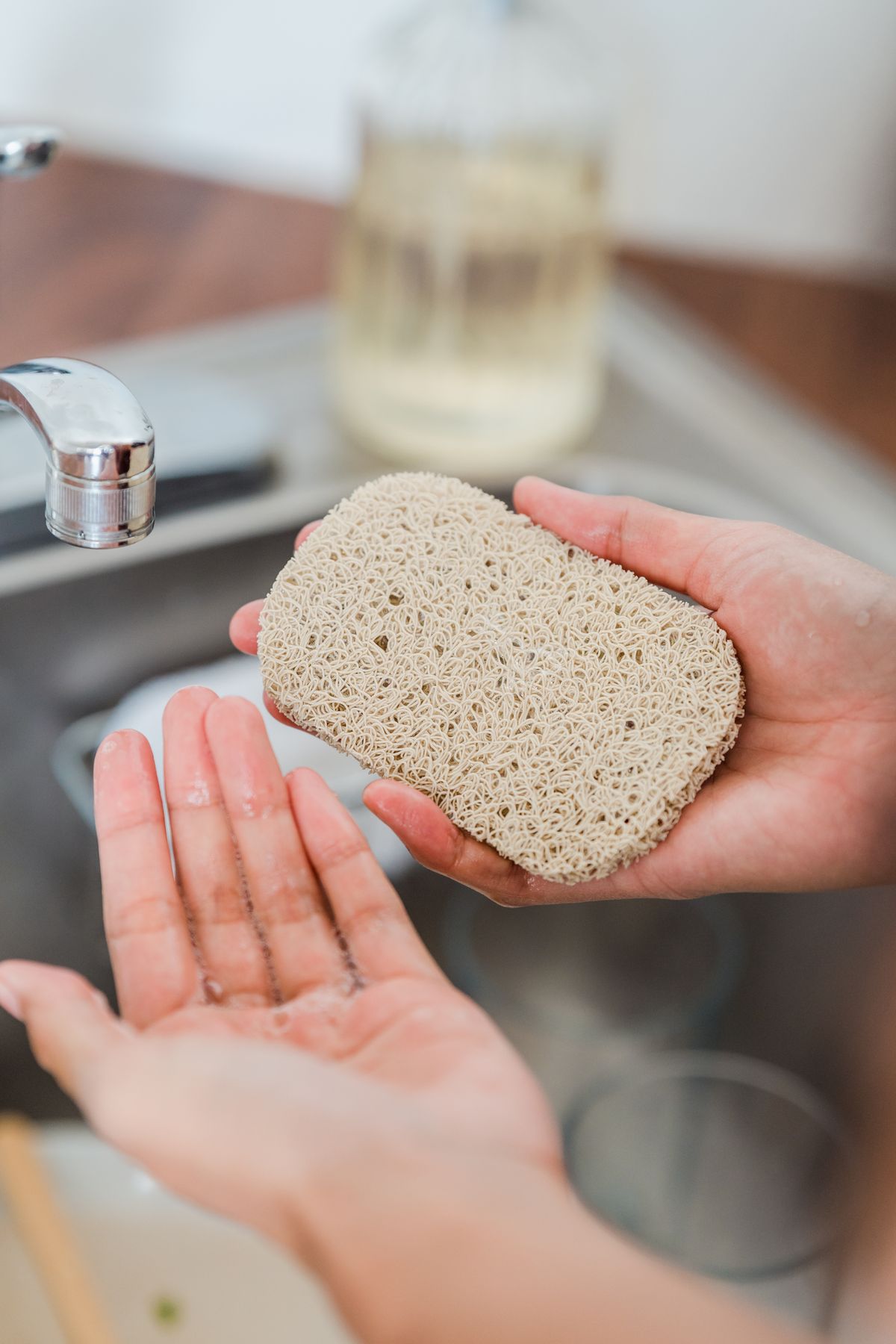 Rinsing a sponge at a kitchen tap